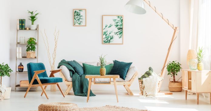 Pineapple on wooden stool in living room with green furniture and braided pouf on carpet