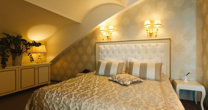 Interior of double bed hotel suite. Luxury golden design of room for just married, copy space